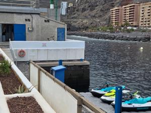 Jet skis lined up by the water with Radazul’s cliffs and apartments in the background.