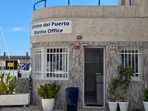 Entrance to the Marina Office building in Puerto de Radazul with plants by the doorway.