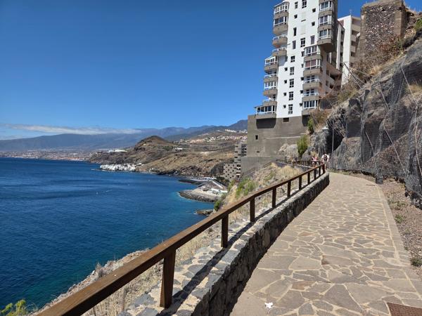 Stone path along cliffs with sea and town views